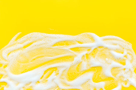 Washing concept. Foam frame on yellow top view copy space.の写真素材