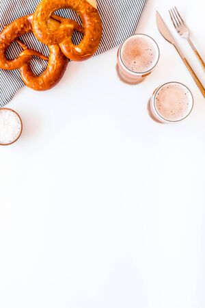 Octoberfest table background. Pretzels and beer glasses on white background top view space for text frameの写真素材