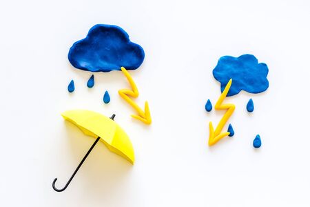 Storm concept, bad weather. Clouds, lightning and umbrella on white background top viewの写真素材