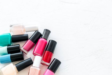 Choose nail polish. Polish bottels on white background top view copy spaceの写真素材