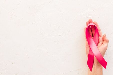 Pink ribbon as symbol of breast cancer awareness on white background top view.の写真素材