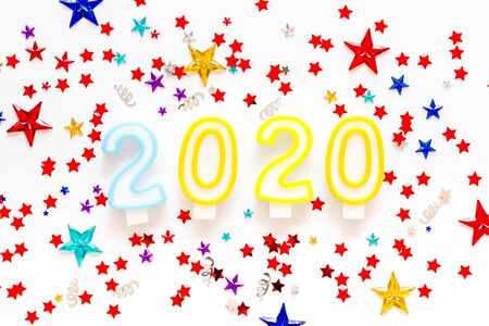 2020 New Year card. Candles and confetti on white background top view.の写真素材