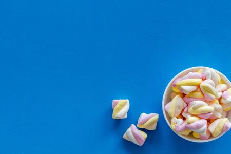 Fluffy dessert. Marshmallows in plate on blue table top view copy spaceの写真素材