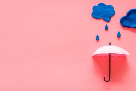 Storm concept, bad weather. Clouds and umbrella on pink background top view.の写真素材