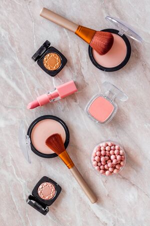 Makeup background with rounge, powder and tools on light brown table top view.の写真素材