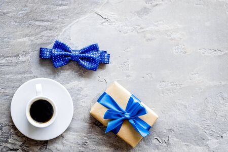 Greeting card for mens birthday. Present box, bow tie and coffee on grey background top view frame copy spaceの写真素材