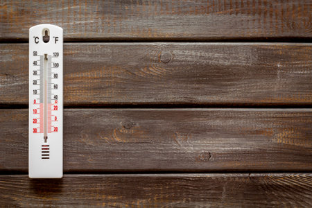 Weather thermometer on dark wooden background top view space for text