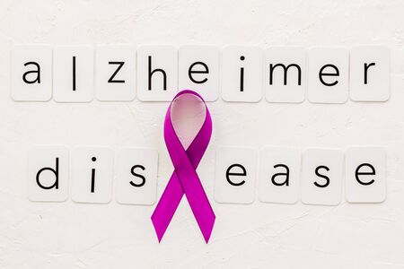 Alzheimers disease text near violet ribbon on white background top viewの写真素材