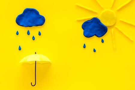 Weather forecast concept. Sunny and rainy. yellow background top view space for textの写真素材