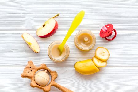 Baby food. Colorful puree in glass jars near vegetables and fruits on white background top view.の写真素材