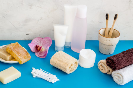 Bathroom accessories set with towels and tooth brushes on blue background.