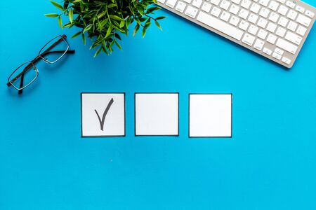 Check mark in check-box of check list on blue background top view.の写真素材