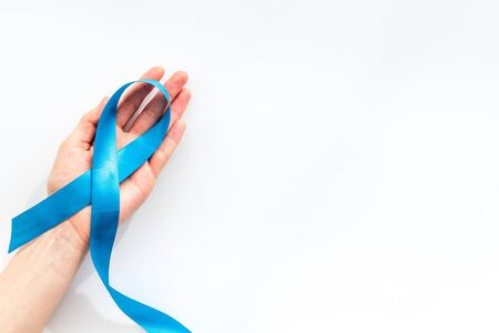 Blue ribbon in hands as symbol disease control on white  top view copy spaceの写真素材