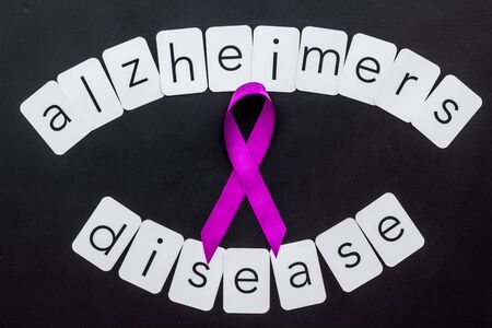Alzheimers disease text near violet ribbon on blackの写真素材