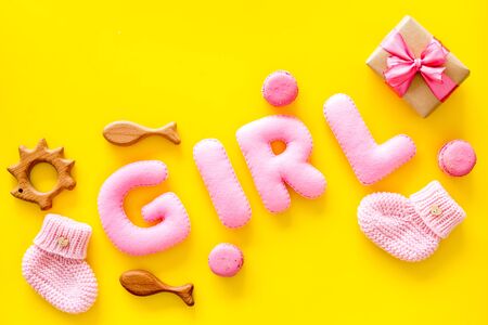 Girls's birthday concept. Pink baby set with gift box on yellow backgound top view.の写真素材