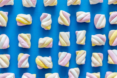 Marshmallows pattern on blue background top view flat lay.
