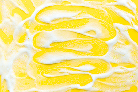 Washing concept. Foam background on yellow top view.の写真素材