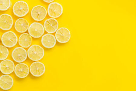 Lemon frame. Sliced citruses on yellow background top view copy space