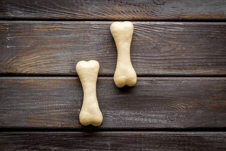 Food and toys for dogs. Chewing bones on dark wooden background top view copy spaceの写真素材