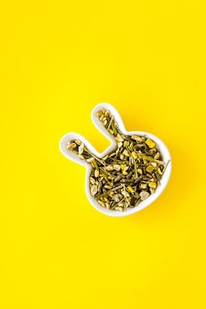 Pet food for rabbits in rabbit-shaped bowl on yellow background top view copy spaceの写真素材