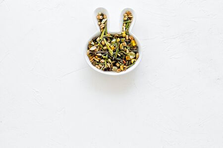 Pet food for rabbits in rabbit-shaped bowl on white background top view copy spaceの写真素材