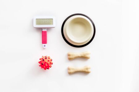 Set of treats and toys for pets with bones, collar and bowl on white background top view flat layの写真素材