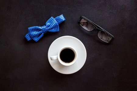 Fathers Day or mens birthday concept. Bow tie, glasses and coffee on black background top viewの写真素材