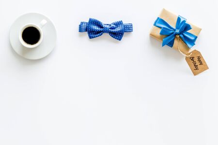 Mens birthday concept. Happy birthday text, present box, bow tie and coffee on white background top view frame copy spaceの写真素材