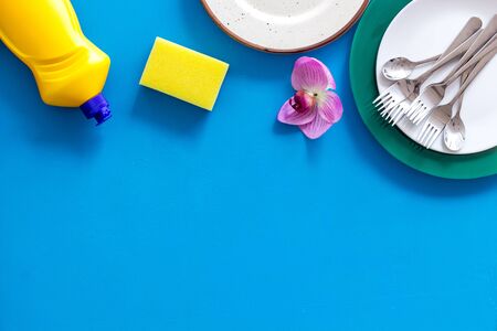 Washing dishes frame with plates, sponges, dishwashing liquid on blue background top view space for textの写真素材