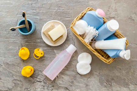 Cute bathroom cosmetics set with yellow rubber duck on grey background top view patternの写真素材