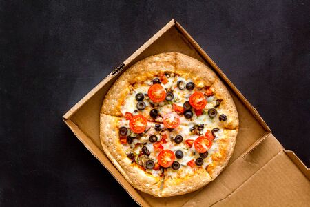 Order pizza to home or office. Italian food in box on black background top view copy spaceの写真素材