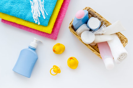 Cute bathroom cosmetics set with yellow rubber duck on white background top view pattern