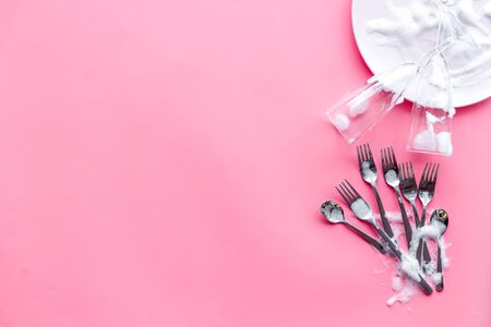 Washing dishes concept. Plates, spoons, forks on pink background top view.の写真素材