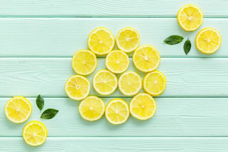 Lemon and leaves pattern on green wooden background top view.の写真素材