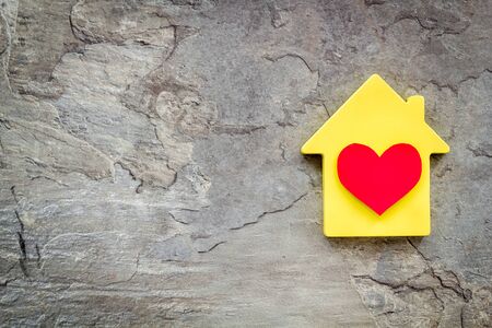 Happy life and home concept. House cutout and heart icon on grey background top view.の写真素材