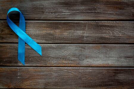 Blue ribbon as symbol disease control on dark wooden background top view copy spaceの写真素材