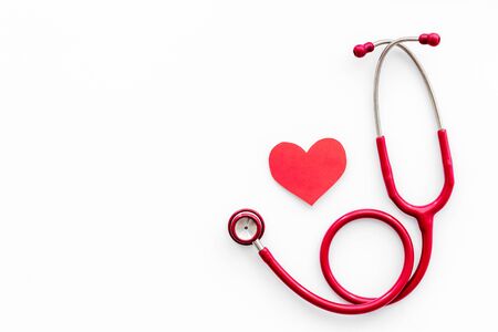 Health care concept. Heart icon and stethoscope on white background top view.