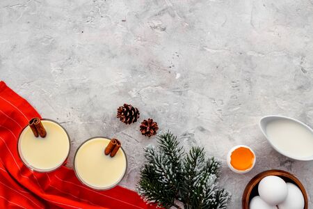 Ingredients for New Year drink eggnog - milk, eggs, cinnamon on grey background top view.の写真素材