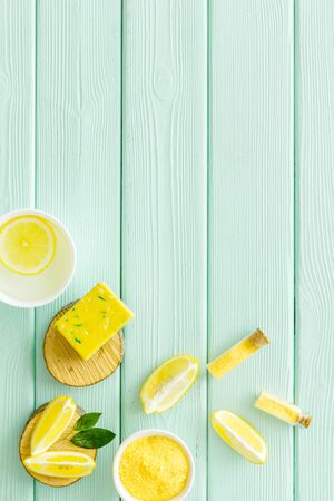 Lemon cosmetics. Cleansing tonic and handmade soap on green wooden background top view frame copy spaceの写真素材