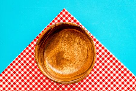 Preparing for lunch - empty wooden bowl closeup on blue background top view.の写真素材