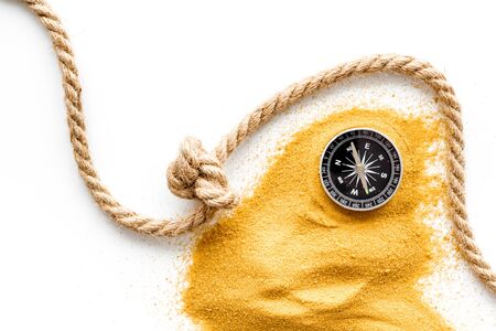 Goal achievement concept. Compass near rope with knot on white background top view.の写真素材