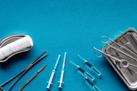 Plastic surgery instruments and tools with bandage on blue background top view frame copy space
