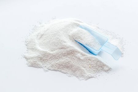 Household chemicals. Washing powder in plastic spoon on white backgroundの写真素材