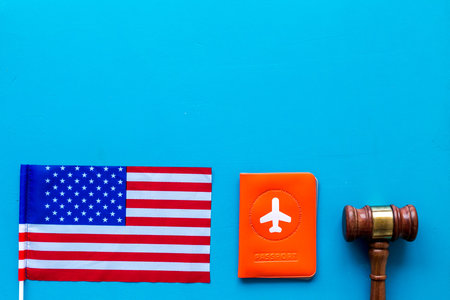 American flag near passport on blue background top view.