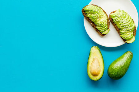 Healthy food. Avocado toast on blue background top view frame copy spaceの写真素材