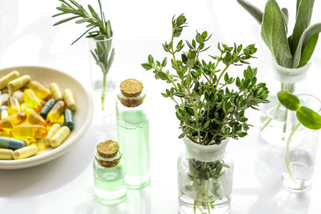 Healing herbs in glasses and medicine on white backgroundの写真素材