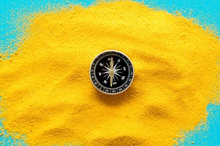 Travel concept. Compass on yellow sand background top view copy spaceの写真素材