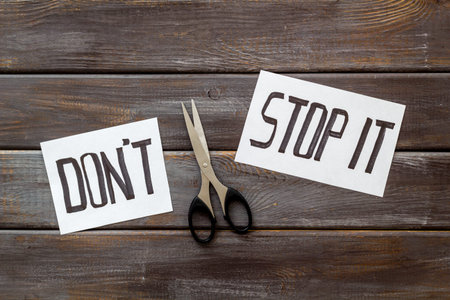 Encouragement and motivation. Cut text Dont stop it near scissors on dark wooden desk