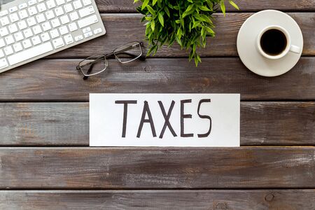 Taxes text on dark wooden office background top view.の写真素材