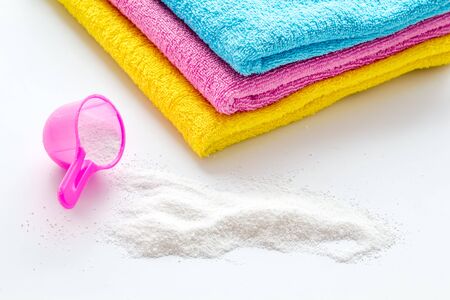 Laundry concept. Clean linen near washing powder on whiteの写真素材